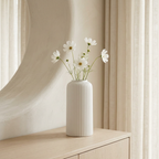 White fluted vase with delicate flowers in a cream interior